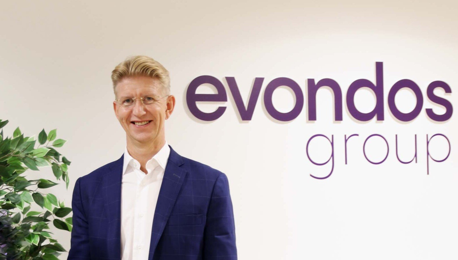 Eetu standing smiling next to Evondos Group logo